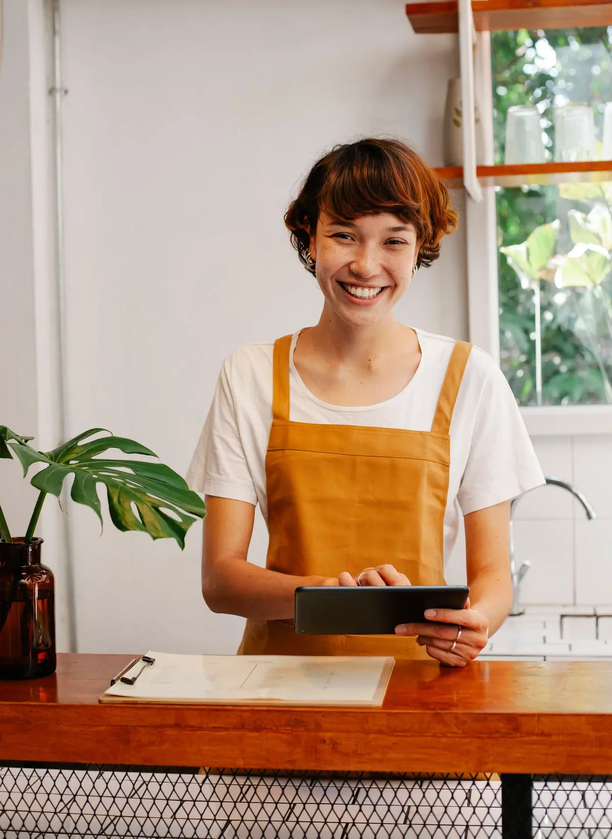 Karyawan kafe memegang tablet di konter