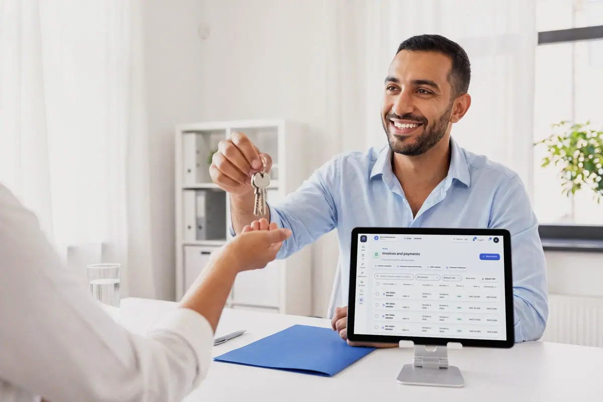 Un agente inmobiliario entregando las llaves a un cliente al otro lado del escritorio